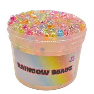 May include: A clear plastic tub filled with colourful slime and rainbow-coloured beads. The tub has a label that reads "RAINBOW BEADZ". The slime is a mix of clear and iridescent colours. A fun sensory toy.