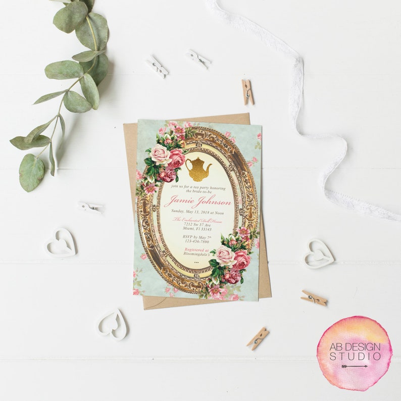 May include: A vintage-style tea party invitation with a gold frame and floral accents. The invitation reads "Join us for a tea party honoring the bride-to-be, Jamie Johnson, Sunday, May 13, 2018 at Noon, The Enchanted Oak Room, 7212  St 37 Ave, Moose, FL 33143, RSVP by May 7th, 123-456-7890, Arranged by Bloomingdale's."