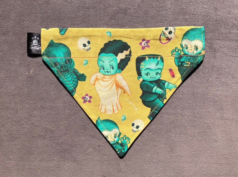 May include: A yellow triangle shaped dog bandana with a green, blue, and white cupie doll Bride of Frankenstein and Frankenstein, Swamp Thoing and Wolf Man