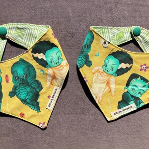 May include: Two yellow fabric bandanas with green, white, and black monster and skull illustrations. The bandanas have a green and white geometric pattern on the reverse side.