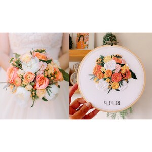 May include: A white embroidery hoop with a floral design in shades of peach, yellow, and green. The date "4.14.18" is embroidered in black thread below the flowers.