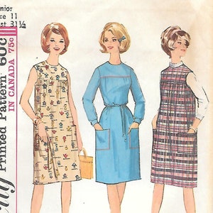 May include: Vintage Simplicity sewing pattern 5402 featuring three dress designs. The pattern includes a sleeveless dress with a novelty print, a long-sleeved dress with pockets, and a plaid jumper. The pattern is for a Junior size 11 with a 31 1/2 inch bust.