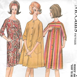May include: A McCall's 7100 printed sewing pattern envelope for a robe set in size medium. The illustration shows three variations of a knee-length robe with three-quarter sleeves, including a paisley print, a solid tan, and a vertical striped design.