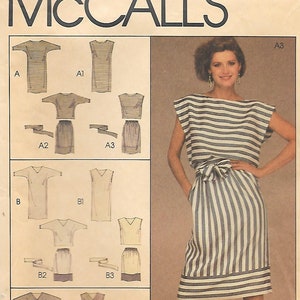 May include: A McCall's 8991 sewing pattern envelope for a dress with vertical blue and white stripes. The front shows a model wearing the dress with a waist tie, while the left side displays technical line drawings of variations A, B, and C.
