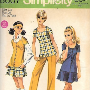 May include: A white ceramic mug with a black handle and the text "But First, Coffee" in a bold, black font. The mug is set against a neutral background, highlighting its simple design.