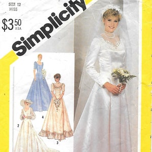 May include: Simplicity sewing pattern 5440 for a wedding dress. The pattern features a bride in a white satin gown with long sleeves, a veil, and a bouquet. Additional dress styles are shown in the image.