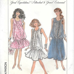 May include: Simplicity sewing pattern 8701 featuring three dress designs. The pattern includes a pink floral dress, a white dress with lace trim, and a blue dress. The text "Great Expectations" and "Lady Madonna" are visible.