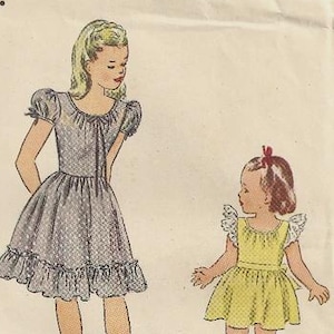 May include: A vintage Simplicity sewing pattern envelope, number 2061, size 6. The front displays illustrations of two dresses: one with puff sleeves and a ruffled hem, and another with flutter sleeves and a back tie. Text includes Simplicity Printed Pattern 25c and Simplicity is America's Fashion.