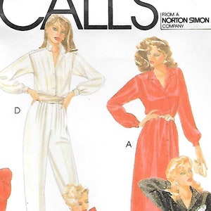 May include: A McCall's sewing pattern envelope, number 7801, featuring illustrations of various outfits including jumpsuits, blazers, and dresses. The white envelope displays the brand name, pattern number, and text indicating bust cup size adjustment darts.