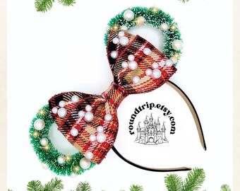 May include: Red and green plaid bow with white pearl accents and a green and white wreath on a black headband. The headband has the text "roundtrip.etsy.com" with a castle graphic.