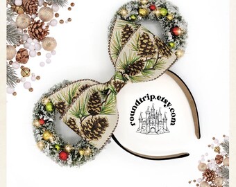 May include: A pair of Christmas-themed Minnie Mouse ears with a green and brown pine cone bow and a wreath with red and gold ornaments. The ears are made of a soft, plush material and are perfect for adding a festive touch to any outfit.