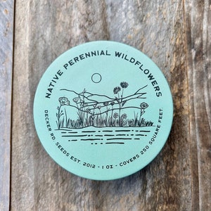 May include: A teal blue round tin with black text that reads "Native Perennial Wildflowers Decker Rd. Seeds Est. 2012 - 1 oz - Covers 250 Square Feet". The tin has a black and white illustration of wildflowers and a sunset.