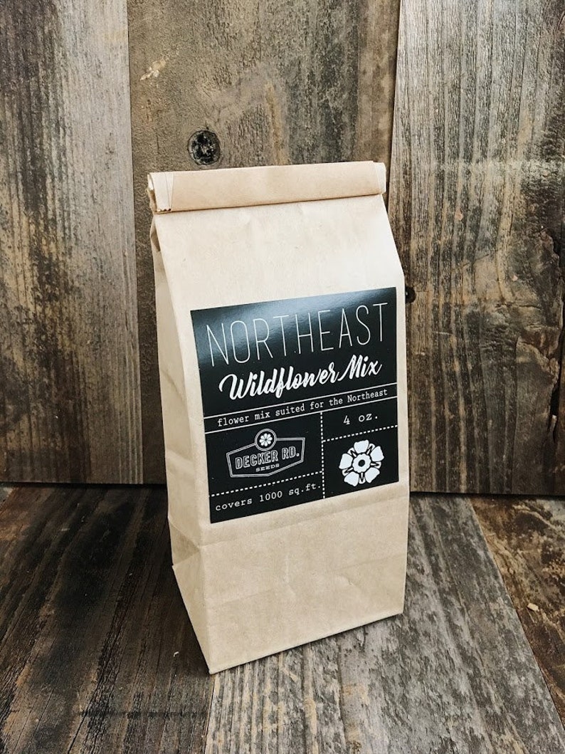 May include: A brown paper bag with a black label that says "Northeast Wildflower Mix" and includes the text "flower mix suited for the Northeast", "Decker Rd.", "covers 1000 sq.ft.", and "4 oz.".