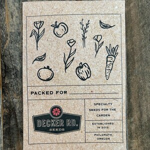 May include: A brown paper card with black illustrations of various garden plants and vegetables. The card has the text "PACKED FOR" at the top and a logo for "DECKER RD. SEEDS" in the center. The text "SPECIALTY SEEDS FOR THE GARDEN" is in the top right corner. The text "ESTABLISHED IN 2012 PHILOMATH, OREGON" is in the bottom right corner.