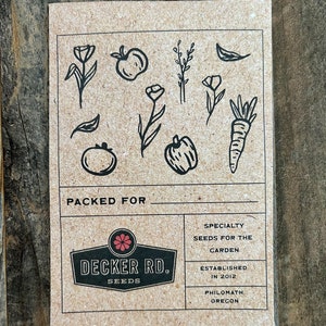 May include: A brown paper card with black illustrations of various garden plants and vegetables. The card has the text "PACKED FOR" at the top and a logo for "DECKER RD. SEEDS" in the center. The text "SPECIALTY SEEDS FOR THE GARDEN" is in the top right corner. The text "ESTABLISHED IN 2012 PHILOMATH, OREGON" is in the bottom right corner.