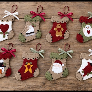 May include: Eight felt Christmas stockings with decorative stitching and ribbon loops. Designs include a heart, ice skate, gingerbread person, snowman, Santa Claus, star, and cardinal bird in red, white, green, and tan colors with satin bows.