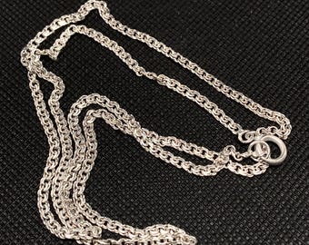 May include: A silver chain necklace with a delicate, twisted design. The chain is made of multiple strands and has a simple clasp.