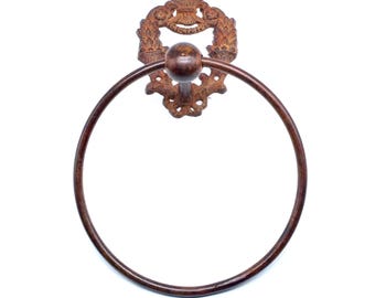Puede incluir: Anillo para toalla de metal marrón rústico con un diseño ornamentado. El anillo está unido a un soporte de pared con un diseño de volutas decorativas.