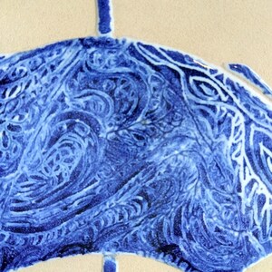 Może przedstawiać: Zbliżenie niebiesko-białej płytki ceramicznej z motywem stylizowanego parasola. Parasol ma szczeg&oacute;łowy, wirujący wz&oacute;r w odcieniach niebieskiego na kremowym tle. Projekt przypomina tradycyjną ceramikę.