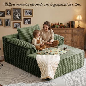 May include: A green corduroy sectional sofa with a matching pillow. A woman and child are seated on the sofa, playing a board game. A cream-colored blanket is draped over the footrest. The text "Where memories are made, one cozy moment at a time." is at the top.