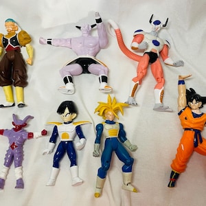 May include: A collection of eight colorful action figures, featuring characters in various poses. The figures showcase a range of colors, including orange, blue, purple, and white, with detailed designs and dynamic stances. The figures are on a white surface.