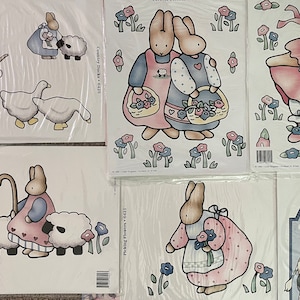 May include: Set of six iron-on transfers featuring cute bunny illustrations. The transfers include bunnies with sheep, ducks, flowers, and a carousel scene. The transfers are designed for use on fabric and are perfect for adding a touch of whimsy to clothing, home decor, or craft projects.