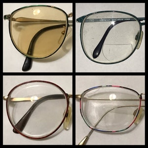 May include: Four pairs of eyeglasses with different colored frames and lenses. The frames are gold-toned with a variety of colored accents. The lenses are clear or tinted.