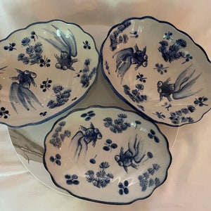 May include: Three oval-shaped ceramic bowls with blue and white designs. Each bowl features a stylised goldfish with a blue and white pattern. The bowls are perfect for serving snacks or desserts.