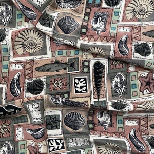 May include: Fabric with a repeating pattern of seashells, starfish, and fish in a variety of shapes and sizes. The design is set against a backdrop of squares in muted colors like pink, gray, and teal. The fabric has a vintage aesthetic.