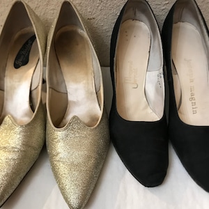 May include: Two pairs of women's high heel shoes. One pair is gold glitter and the other pair is black. The gold glitter shoes have the text "Guess Walker" on the inside. The black shoes have the text "John Magnin" on the inside.