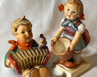 Escolha a sua estatueta vintage de cerâmica Goebel M J Hummel: menino alemão tocando acordeão, pássaro cantando "Vamos Cantar" ou menina segurando uma cesta, pequena ajudante.