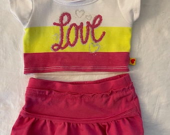 Elige tu vestido de fiesta Build a Bear BABW de lentejuelas, purpurina, tul o conjunto de camiseta en rosa, morado y tonos pastel con estampado de corazones bordados.