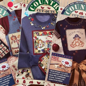 May include: Three packages of Country Cut-Outs no-sew appliques. Each package features a different design: a blue sweatshirt with a button design, a blue t-shirt with a teddy bear design, and a blue vest with a girl and doll design. Each package includes a free sponge and instructions.