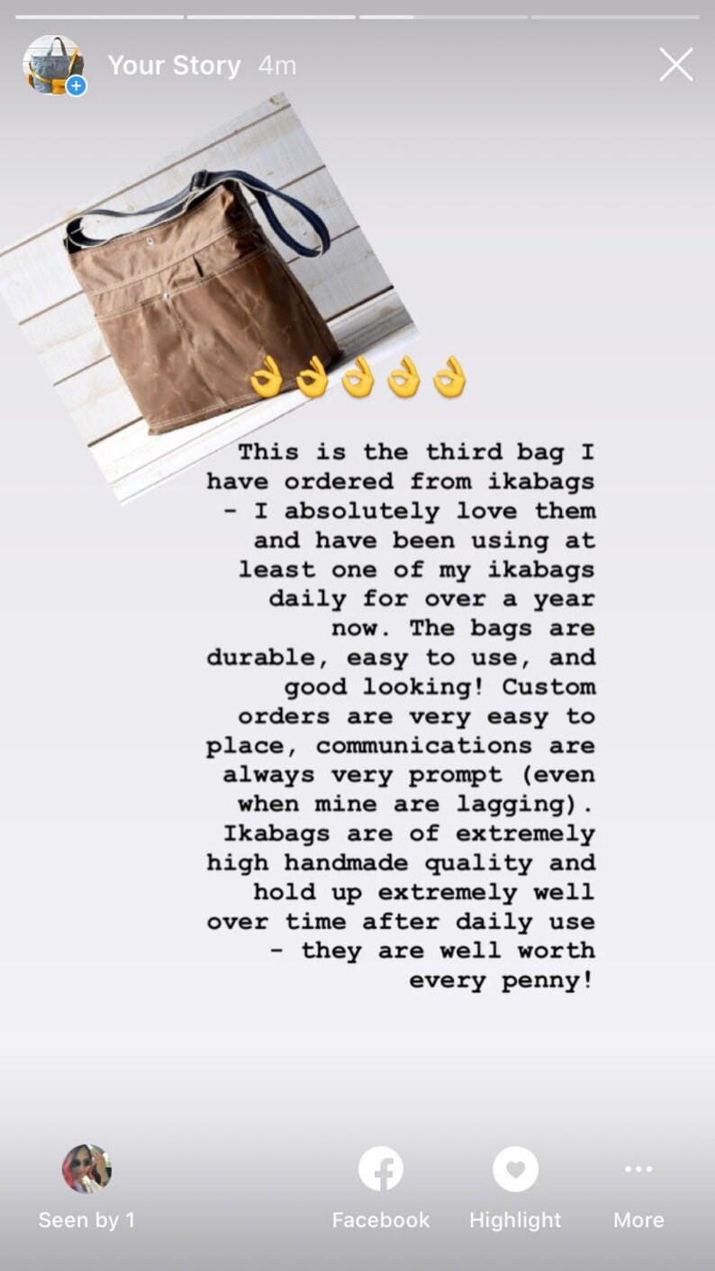 May include: A brown canvas crossbody bag with a dark blue adjustable shoulder strap, featuring a front pocket with a silver metal snap button closure and visible stitching details across the exterior surface of the bag.