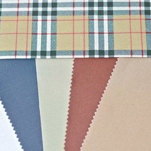 May include: Five fabric swatches in different colors and textures. The swatches are arranged horizontally, with a plaid fabric at the top. The swatches are white, blue, beige, brown, and tan.