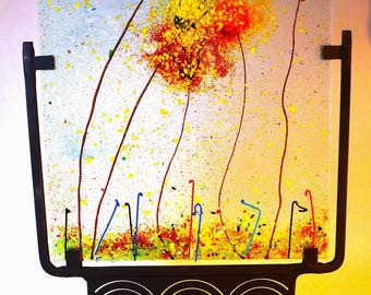 Fused glass flowers on heavy metal stand.