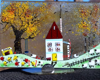 Fused glass Farmhouse on a rock stand.