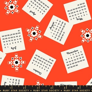 May include: A repeating pattern of white floral designs on a bright orange background. Each floral design has a black center and white petals. Each floral design is surrounded by a white square with black text that reads the months of the year and the days of the month.