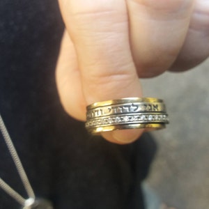 K&ouml;nnte beinhalten: Ein goldener Ring mit einer Band aus hebr&auml;ischem Text und einer Reihe kleiner Diamanten.