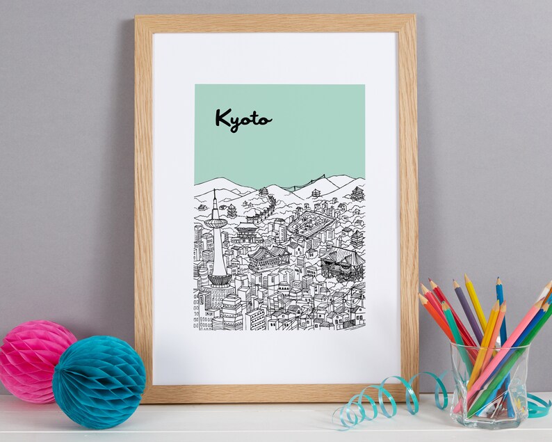 May include: A framed print with a black and white illustration of the Kyoto skyline. The print has a light green background and the word "Kyoto" in black lettering at the top.