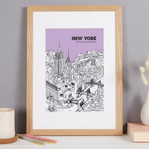 May include: Framed black and white illustration of the New York City skyline, with a lavender background and the text "NEW YORK" and "Our Honeymoon April 2016". The artwork is in a light wood frame.