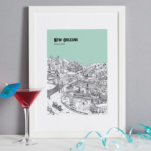May include: A framed print of a black and white illustration of the New Orleans skyline with the text "NEW ORLEANS" and "January 2016" on a light green background.