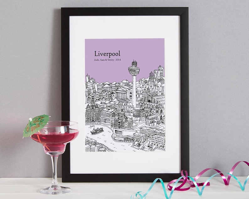 Op de afbeelding: Een zwart ingelijst print met een paarse achtergrond met een lijntekening van de skyline van Liverpool. De tekst "Liverpool" staat bovenaan de print, met de tekst "Jude, Sam & Wendy - 2014" eronder.