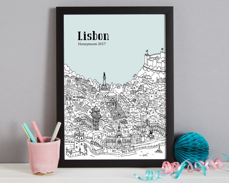 May include: A black and white line drawing of the city of Lisbon, Portugal. The drawing includes the iconic landmarks of the city, such as the Castelo de S&atilde;o Jorge and the Jer&oacute;nimos Monastery. The text "Lisbon Honeymoon 2017" is printed at the top of the drawing.
