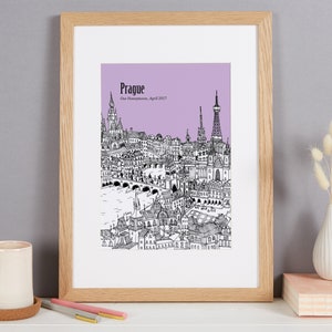 Op de afbeelding: Een zwart-witte lijntekening van de skyline van Praag op een lichtpaarse achtergrond. De tekst "Praag" en "Onze huwelijksreis, april 2017" staat onder de afbeelding.