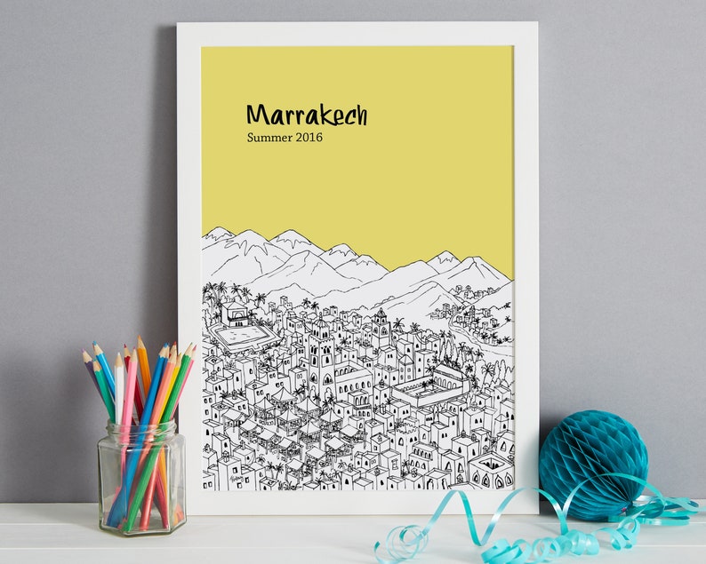 May include: A black and white line drawing of the city of Marrakech, Morocco, with a yellow background. The text "Marrakech" and "Summer 2016" is printed below the drawing.