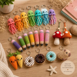 May include: A collection of handmade crochet keychains featuring various designs including jellyfish in pink, orange, yellow, green, blue, and purple, pencil shapes, red and orange mushrooms, carrots, donuts, and a capybara, all with metal rings.