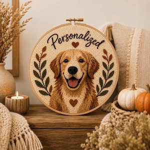 May include: A circular embroidery hoop featuring a textured, yarn-based portrait of a golden retriever dog. The dog is centered with a smiling expression, flanked by two green and brown leaf sprigs. The word Personalized is stitched above the dog.