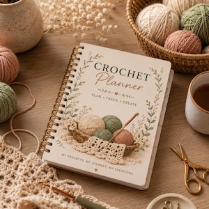 Può includere: Un'agenda per uncinetto a spirale con copertina color crema, bordo floreale, illustrazioni di gomitoli di lana in un cestino e il testo "CROCHET Planner PLAN • TRACK • CREATE" e "MY PROJECTS, MY JOURNEY, MY CREATIONS" in verde scuro e marrone.
