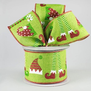 May include: A spool of lime green wired ribbon featuring a repeating pattern of red and white glittered elf hats and striped elf legs with curled shoes. The ribbon has a textured burlap-like finish and red stitched edges along the top and bottom.